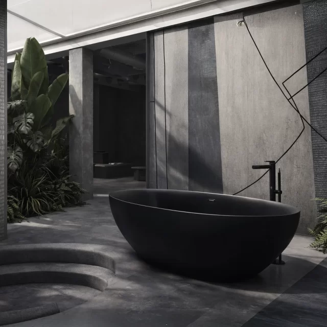 Vasca da bagno freestanding ovale a forma di mandorla in metacrilato nero opaco a doppio strato, posizionata al centro di un ambiente zen rivestito con carta da parati decorartiva, rubinetteria a pavimento cromata.